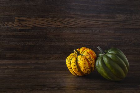 yellow and green sweet dumpling squash against a wood backgroundの写真素材