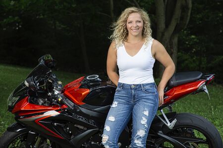 Young woman leaning on a sport motocyleの写真素材