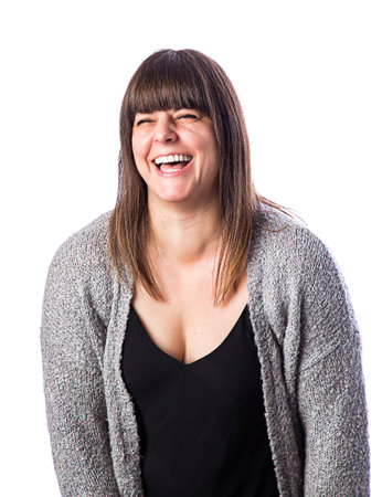 Isolated portrait of a forty year old woman, wearing a gray vest, laughing her hear outの写真素材