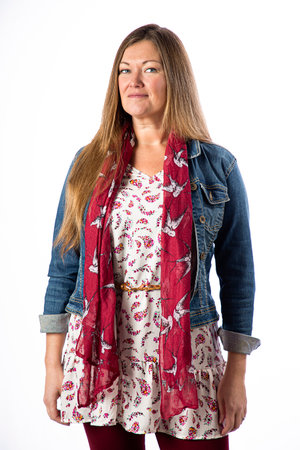 Isolated portrait of a forty year old woman, wearing a jean jacket, red scarf and relaxed top