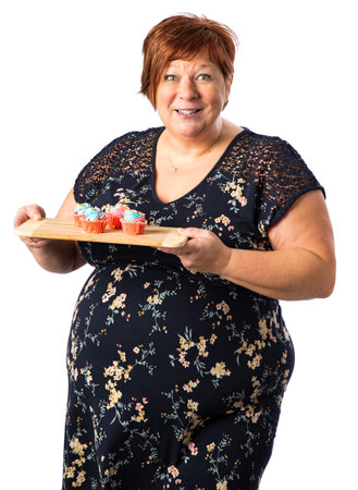 Fifty something woman offering a plate of small cupcakeの写真素材