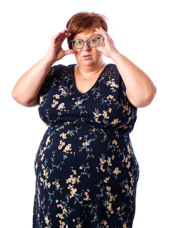Overweight fifty woman holding her glasses to her faceの写真素材