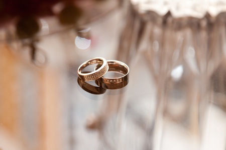 Wedding rings on a glass tableの写真素材