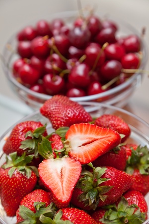 Ripe, red cherry and strawberry in a glass cupの写真素材