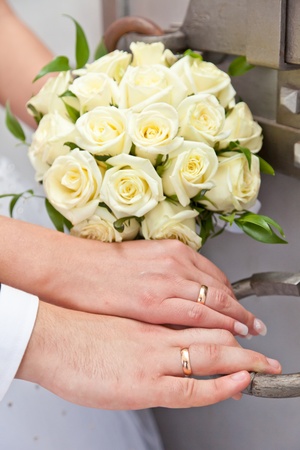 Hands with wedding rings and a wedding bouquetの写真素材