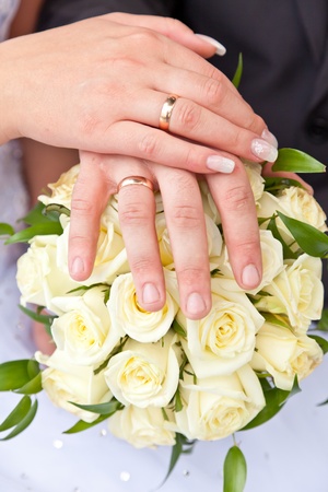 Hands with wedding rings on a wedding bouquetの写真素材