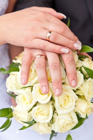 Hands with wedding rings on a wedding bouquetの写真素材