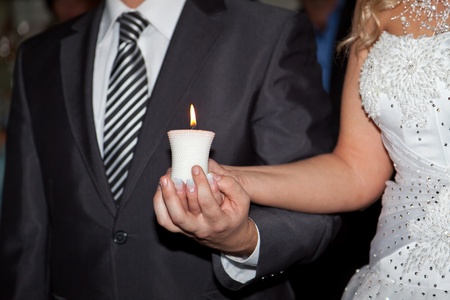 Burning candle in hands の写真素材
