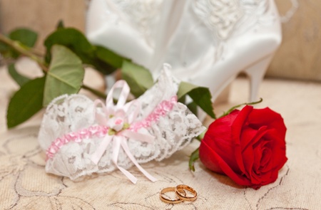 Garter, rings and a red roseの写真素材