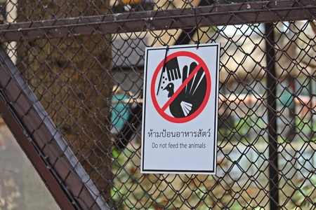 Sign,  in a zoo at Thailand,  tell to tourist are careful.