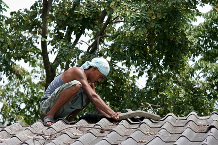 UDONTHANI, THAILAND  MARCH 23, 2018:  REPAIRMAN,  he is repairing roof,  be the roof of school building at UDOTHANI province THAILAND.のeditorial素材