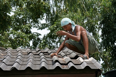 UDONTHANI, THAILAND  MARCH 23, 2018:  REPAIRMAN,  he is repairing roof,  be the roof of school building at UDOTHANI province THAILAND.のeditorial素材