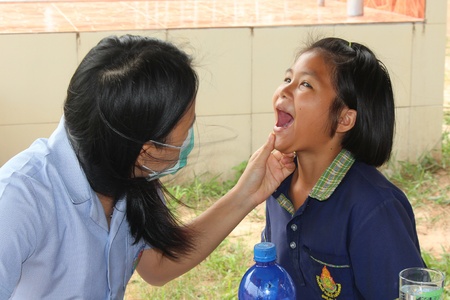 UDONTHANI, THAILAND â€“ JUNE 12, 2018:  Doctor,  she is checking the oral cavity of a student, ...