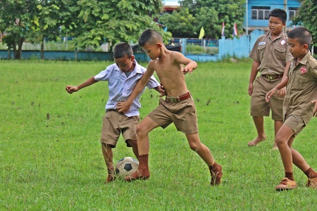 UDONTHANI, THAILAND â AUGUST 16, 2018:  Asian students are playing football on green lawn,  see them in BAN HUA KUA MUEAD AE school,  at UDONTHANI province THAILAND.のeditorial素材