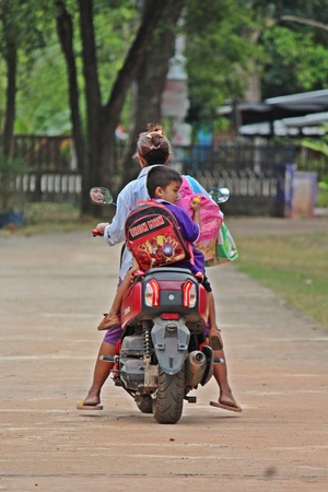UDONTHANI, THAILAND â JULY 13, 2019 :  The parent, be taking her son for getting back to home by motorcycle,  after school in the evening,  see them at BAN NONG WANG NON KHI LEK school.のeditorial素材