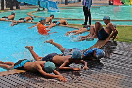 UDONTHANI, THAILAND â€“ OCTOBER 4, 2019:  Asian children stay at rim of pool,  they are...