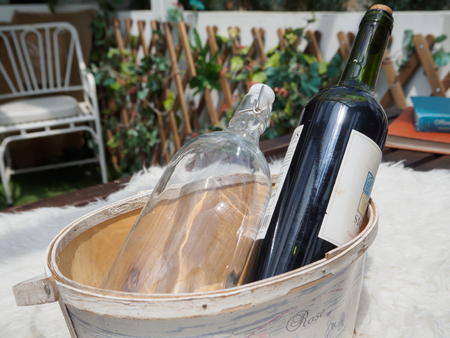 Wine bottles and glass bottles in wooden bucketsの写真素材