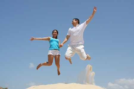 Young man and woman jumpingの写真素材