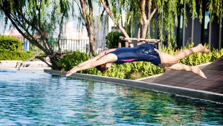 woman jumping into the pool