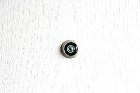 close up door lens peephole on white wooden textureの写真素材
