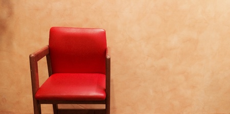 Red leather chair in warm light on the cement texture の素材