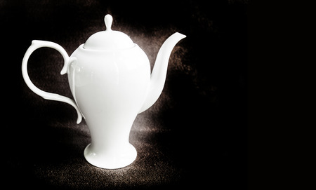 high tea pot white ceramic grossy on classic dark backgroundの写真素材