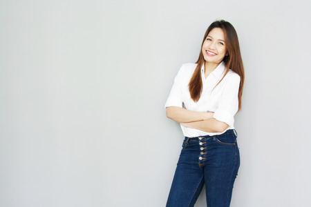 potrait Asian lady smile in casual suite White Shirt and blue jeansの写真素材