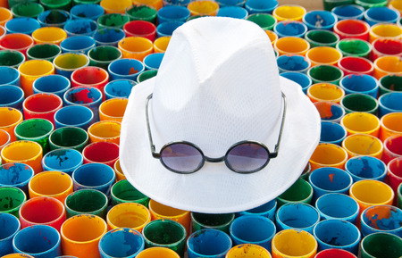 close up white hat and subglasses on colorful painting on glass arranging for abstract backgroundの写真素材