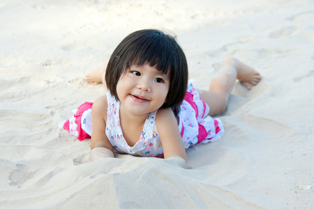happy girl children playing on white sandの写真素材