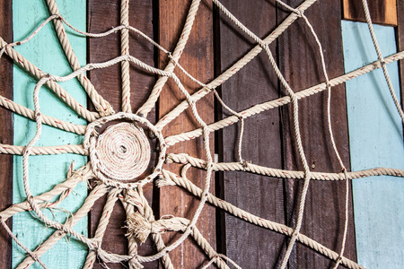 Spider web made of rope on the wood wallの写真素材