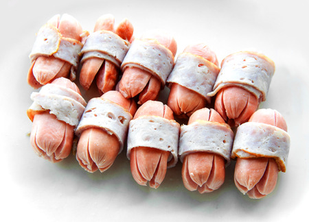 close up boiled bacon wrapped sausageson isolateの写真素材