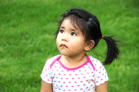 Thai girl watching upper with green backgroundの写真素材