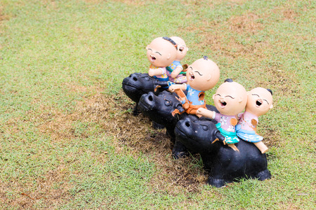 smile children ride buffalo with bake cray decoration outdoor parkの写真素材