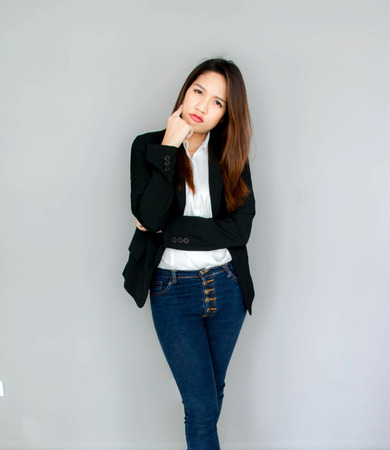 asian girl think action with black suite and blue jeans business conceptの写真素材