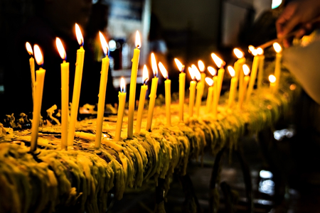yellow candle ligthing in dark nightの写真素材