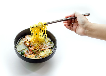 hand keep shopstick to eat red pork noodle on whiteの写真素材