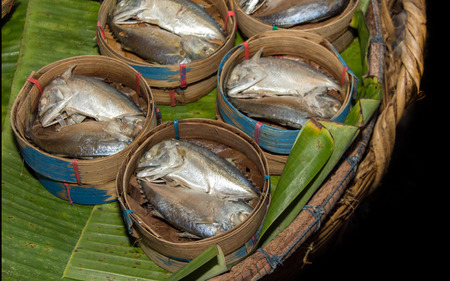 close up fresh fish in basket and green banana leaf at marketの写真素材