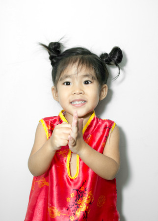 asian girl smiling and greeting action with red Chinese suite styleの写真素材