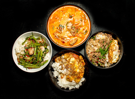 four favorite Thai food menu Krapoa,Tom-yum,soup,omelette on dark backgroundの写真素材
