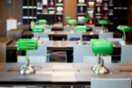 abstract blur reading desk in library for background