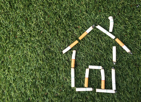 home symbol from cigarette on green glassの写真素材