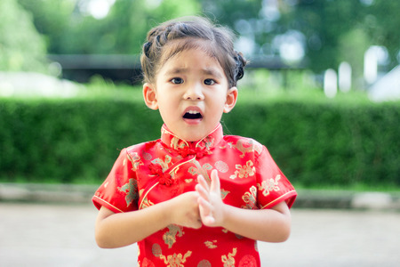 close up asian girl in red china dress looking upの写真素材