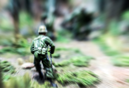 abstract zoom in soldier toy moving in the jungle forest for warの写真素材