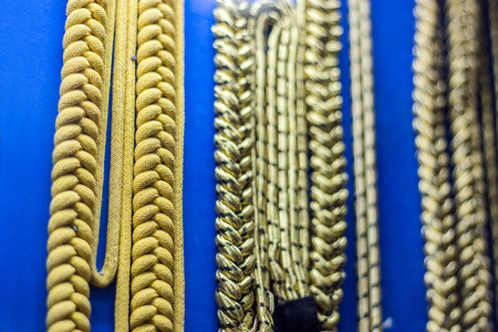 close up golden rope in arm uniform soldier on hornor shelder and chese