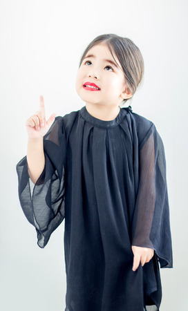 asian girl red lip and point up action in luxury black dressの写真素材