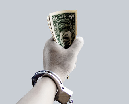 close up hand hold banknote with silver chain in corruption concept の写真素材