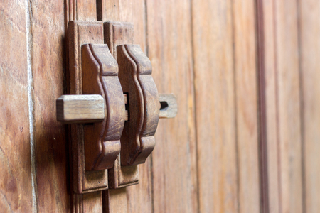closeup wood handle lock door in wooden interiorの写真素材