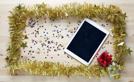 celebrate frame with froid fur and gift present box on wood plate and tablet for backgroundの写真素材
