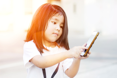 asian girl control everything with smartphone from touch screen in digital behavior lifestyle in morning to nightの写真素材