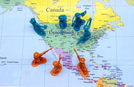 close up plastic toy model in war wall with united state and maxico border concept on world mapの写真素材